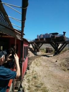 Riding a train with the Superstitions behind us going under a bridge.